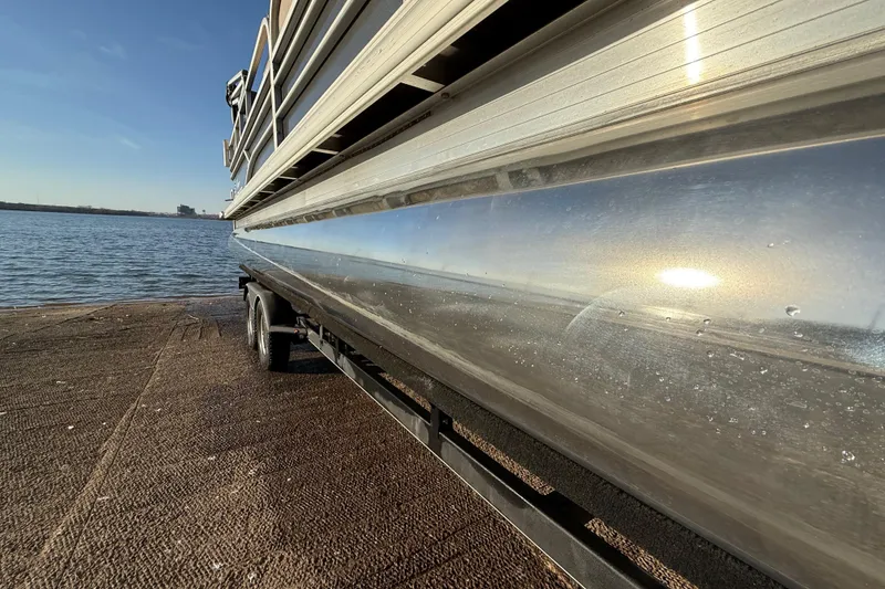 Slide: The Image of 2017 Sun Tracker Party Barge 24 DLX pontoon boat on trailer by the water. - 33