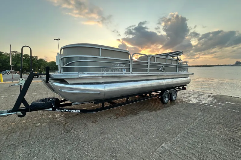 Slide: The Image of 2017 Sun Tracker Party Barge 24 DLX pontoon boat on trailer at sunset by the water. - 66