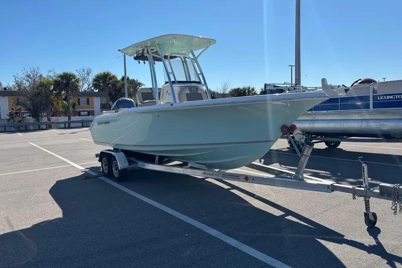 Slide: The Image of 2025 Key West 239 FS boat on trailer in sunny parking lot. - 0