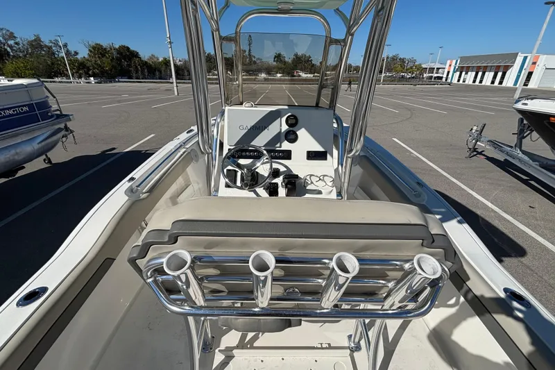 Slide: The Image of 2025 Key West 239 FS boat interior with steering console and rod holders in a parking lot. - 11
