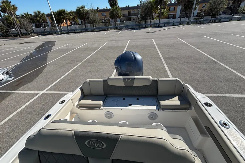 Slide: The Image of 2025 Key West 239 FS boat interior with seating, parked in an empty lot. - 12