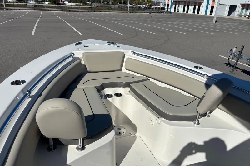 Slide: The Image of 2025 Key West 239 FS boat interior with cushioned seating in a parking lot. - 15