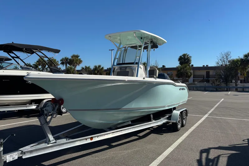 Slide: The Image of 2025 Key West 239 FS boat on trailer in sunny parking lot. - 2