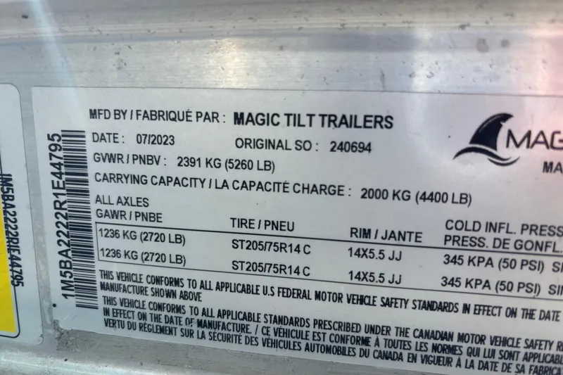 Slide: The Image of Label on Magic Tilt Trailers, detailing weight and tire specifications, dated 07/2023. - 22