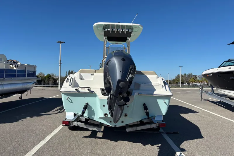 Slide: The Image of 2025 Key West 239 FS boat with outboard motor, parked in a lot under clear blue sky. - 5