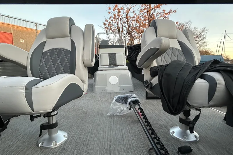 Slide: The Image of Captain's chair on 2018 Misty Harbor 210 RF pontoon boat, docked near a blue truck. - 25
