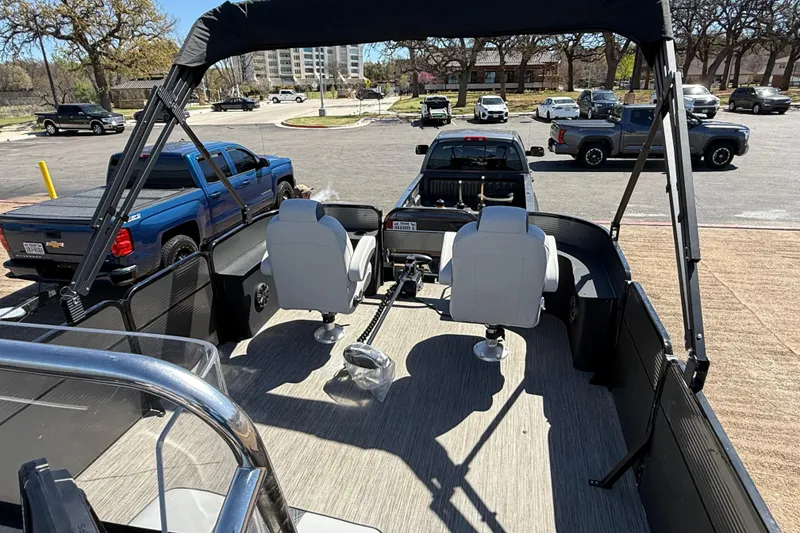 Slide: The Image of 2018 Misty Harbor 210 RF pontoon boat interior with seating and canopy in parking lot. - 38