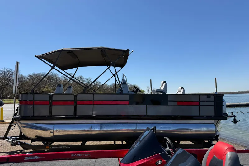 Slide: The Image of 2018 Misty Harbor 210 RF pontoon boat with canopy, parked by a lake under clear blue sky. - 45