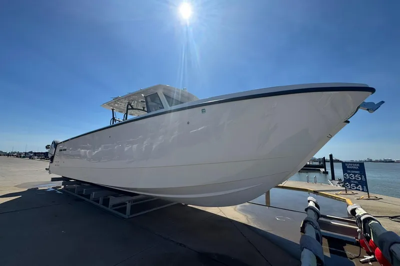 Slide: The Image of 2023 Twin Vee 400 GFX CC boat on display at marina under clear blue sky. - 1