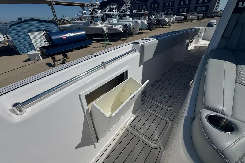Slide: The Image of 2023 Twin Vee 400 GFX CC boat interior with open storage compartment and seating area. - 12
