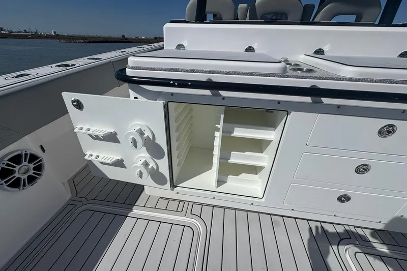 Slide: The Image of 2023 Twin Vee 400 GFX CC boat interior with open storage compartment and seating. - 16