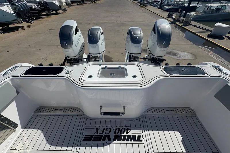 Slide: The Image of 2023 Twin Vee 400 GFX CC boat with four Suzuki outboard engines at a marina. - 18