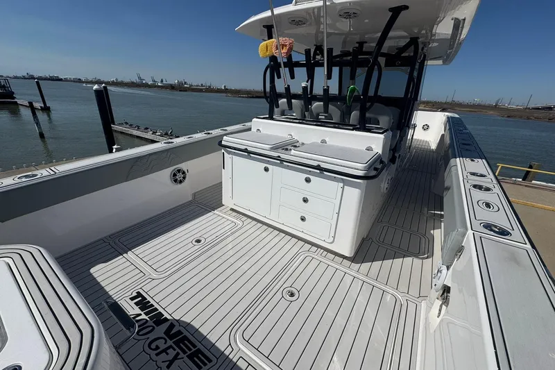 Slide: The Image of 2023 Twin Vee 400 GFX CC boat interior with spacious deck and fishing rod holders. - 19