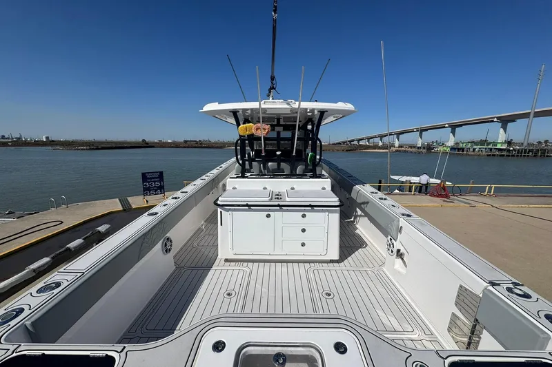 Slide: The Image of 2023 Twin Vee 400 GFX CC boat docked, showcasing spacious deck and modern design. - 22