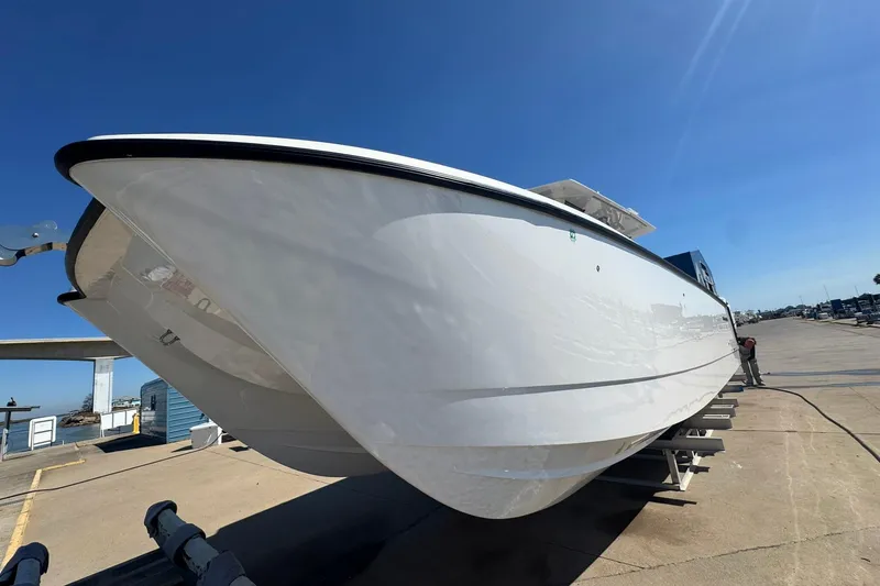 Slide: The Image of 2023 Twin Vee 400 GFX CC boat on a trailer under clear blue sky. - 3