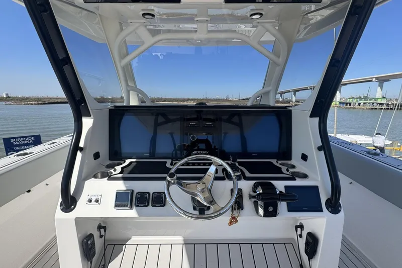 Slide: The Image of 2023 Twin Vee 400 GFX CC boat dashboard with steering wheel and digital displays. - 5