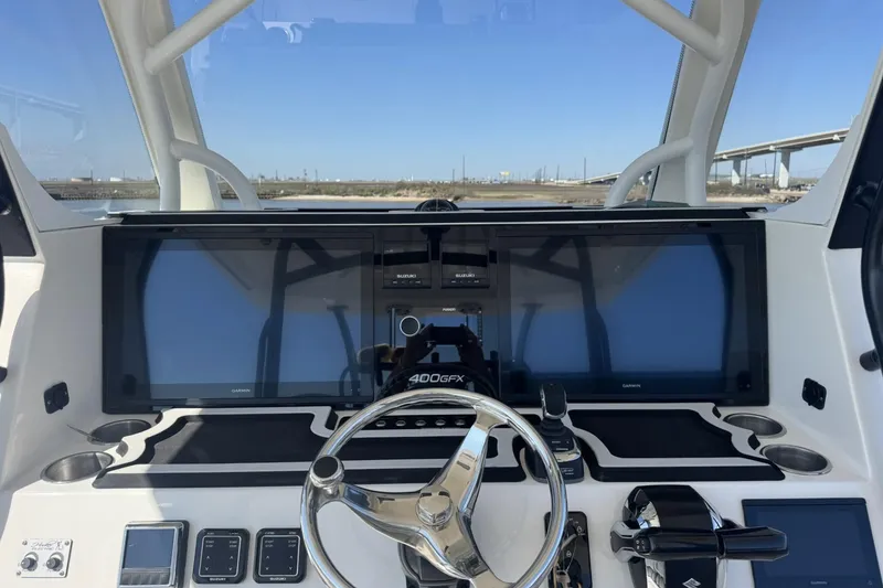 Slide: The Image of 2023 Twin Vee 400 GFX CC boat dashboard with modern controls and dual Garmin screens. - 7