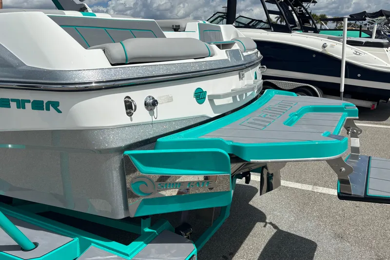 Slide: The Image of 2022 Malibu Wakesetter 23 LSV boat with teal accents and Surf Gate feature. - 18