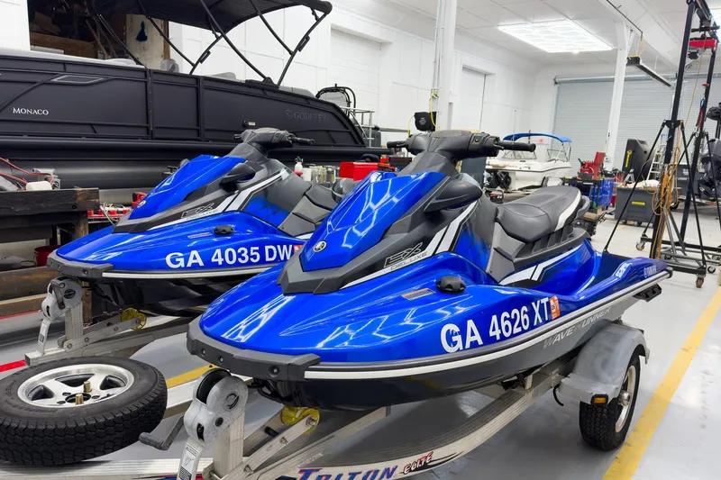 Slide: The Image of 2018 Yamaha WaveRunner EX Deluxe jet skis in a workshop setting. - 0