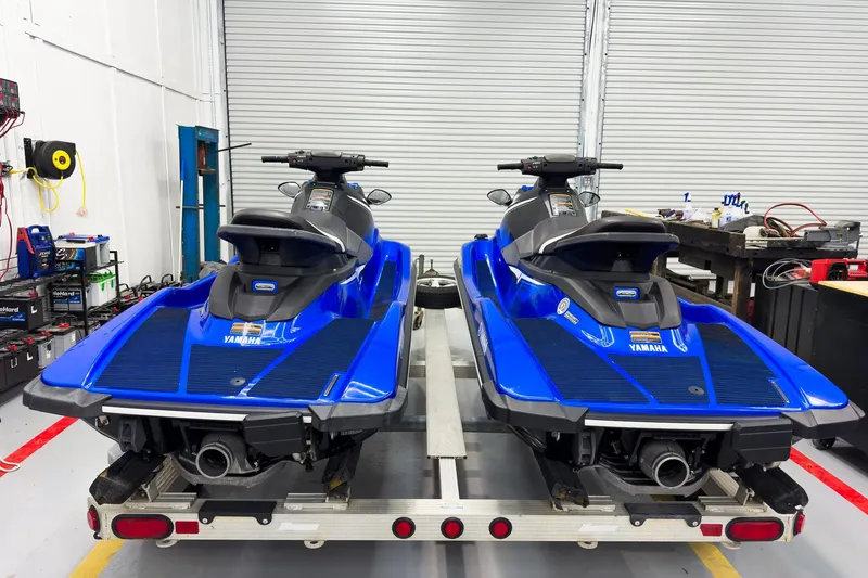 Slide: The Image of Two 2018 Yamaha WaveRunner EX Deluxe jet skis on a trailer in a garage. - 4