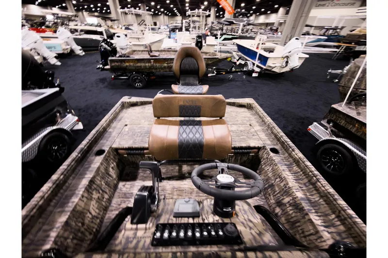 Slide: The Image of 2026 Excel 220 Bay Pro Elite boat interior at a boat show, featuring camo design and steering console. - 7