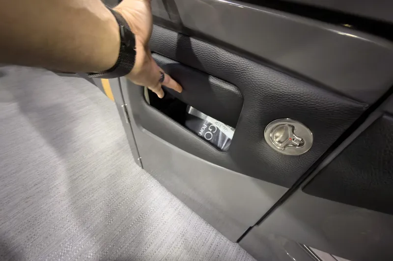 Slide: The Image of Hand opening storage compartment on 2026 Godfrey Monaco 255 Ultra Lounge boat. - 18