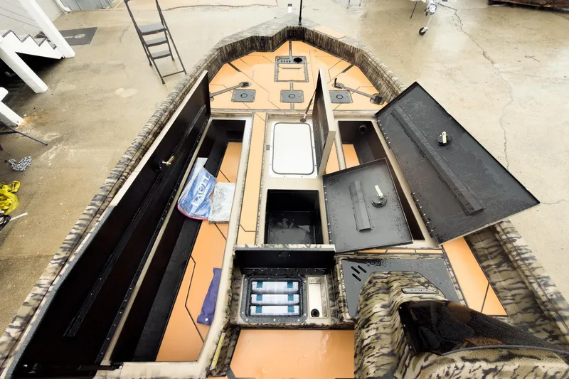 Slide: The Image of 2026 Excel EX203C Crappie & Bass boat with open storage compartments and camouflage design. - 22