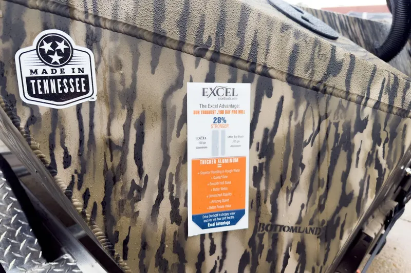 Slide: The Image of Camouflage-patterned Excel EX203C boat with "Made in Tennessee" sticker and durability features. - 25