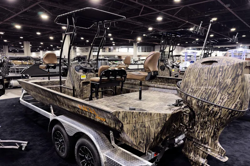 Slide: The Image of 2026 Excel 216 Stalker Center Console boat with camouflage design on display indoors. - 3