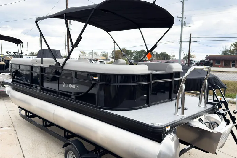 Slide: The Image of 2026 Godfrey Sweetwater Xperience 20' Split Bench Pontoon, sleek design, black exterior, docked. - 19