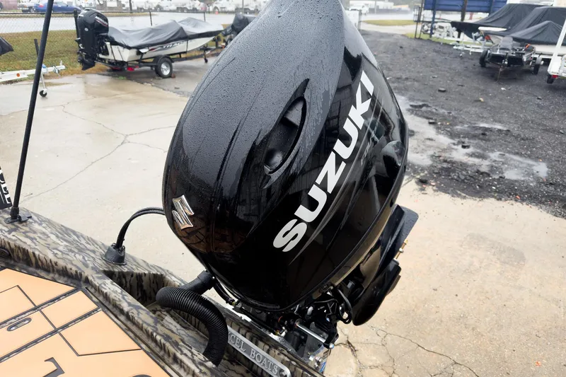 Slide: The Image of 2026 Excel EX203C Crappie & Bass boat with Suzuki outboard motor in a parking area. - 29