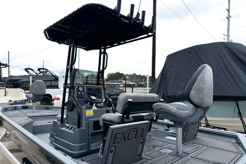 Slide: The Image of 2026 Excel Bay Pro Elite 230 boat with T-top and dual seating, displayed outdoors. - 18