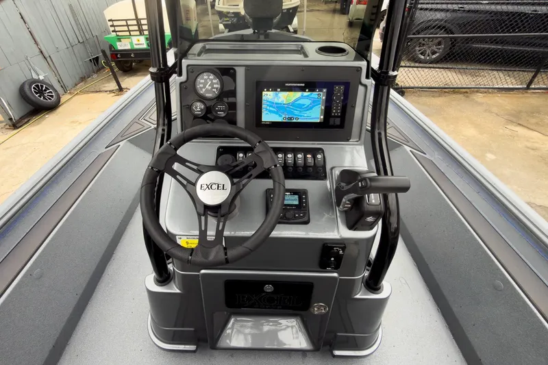 Slide: The Image of 2026 Excel Bay Pro Elite 230 boat dashboard with steering wheel and navigation display. - 21