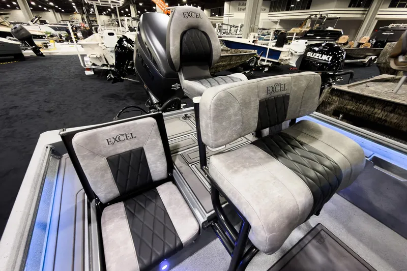 Slide: The Image of 2026 Excel 230 Bay Pro Elite boat interior with cushioned seating at a boat show. - 9