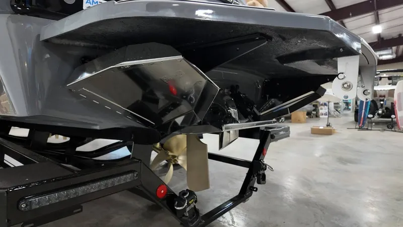 Slide: The Image of Rear view of 2026 MasterCraft XT23 boat in a warehouse setting. - 13