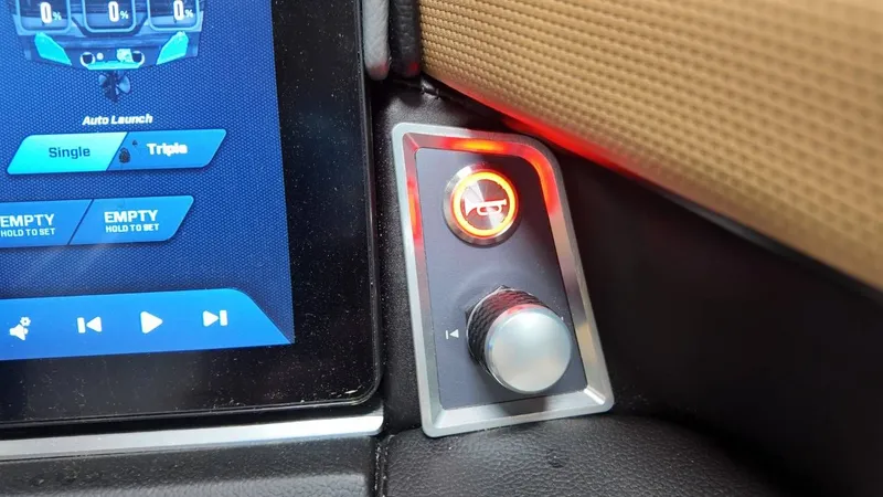 Slide: The Image of MasterCraft XT23 2026 boat control panel with display and knob. - 37