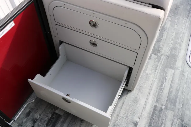 Slide: The Image of Open storage drawer on 2019 Crest II 240 SL boat, featuring sleek design and wood flooring. - 33