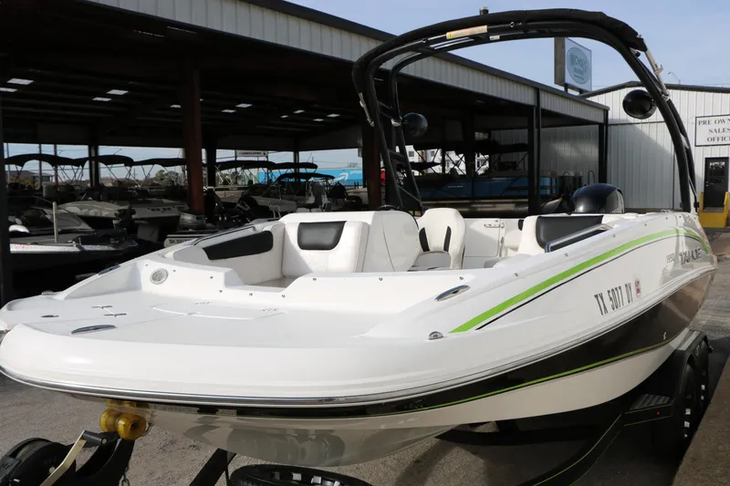 Slide: The Image of 2017 Tahoe 1950 boat with sleek design, parked in a marina showroom. - 8