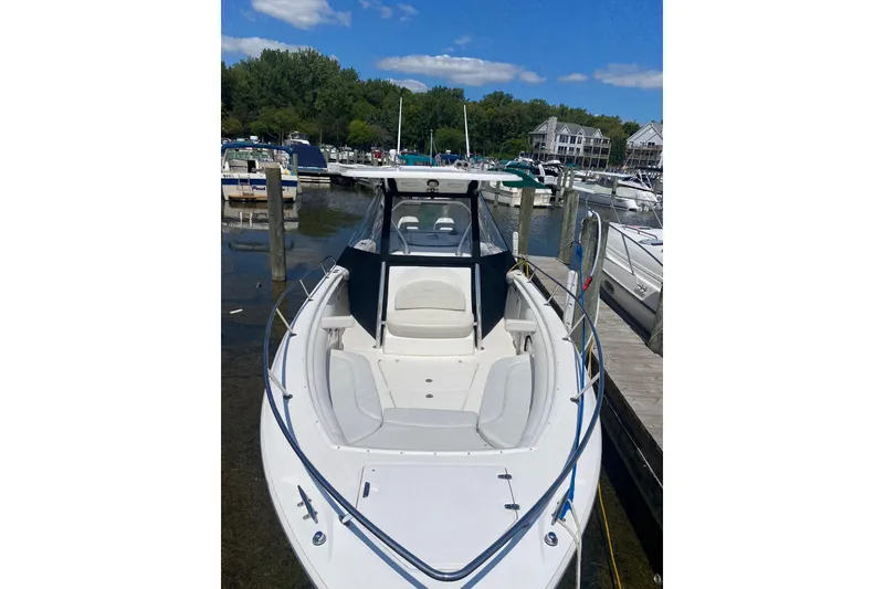 Slide: The Image of 2006 Boston Whaler 320 Outrage docked at a marina under a clear blue sky. - 6