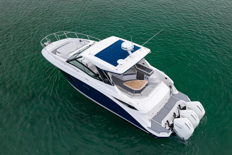 Slide: The Image of 2020 Sea Ray Sundancer 320 Outboard cruising on clear green water. - 11