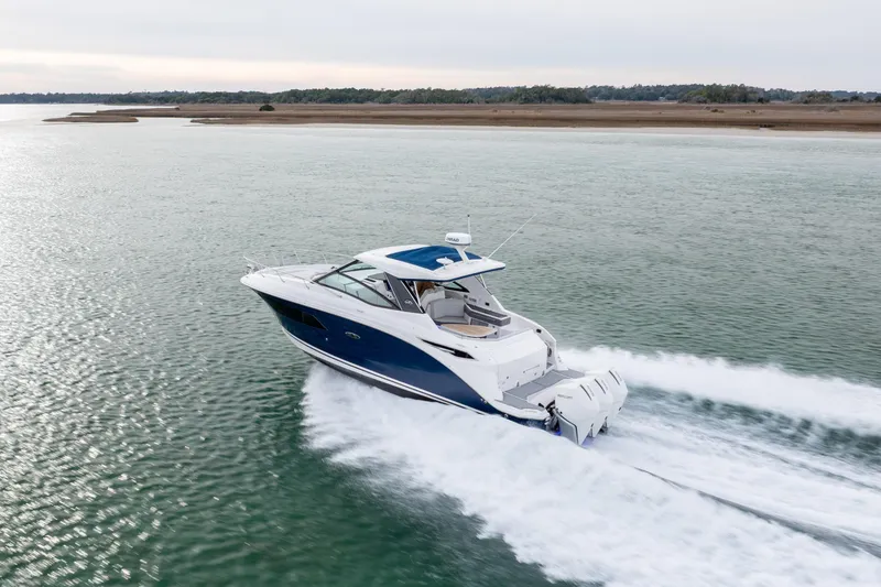 Slide: The Image of 2020 Sea Ray Sundancer 320 Outboard cruising on open water, showcasing sleek design and performance. - 13