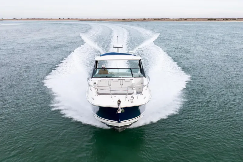 Slide: The Image of 2020 Sea Ray Sundancer 320 Outboard cruising on open water, creating a dynamic wake. - 17