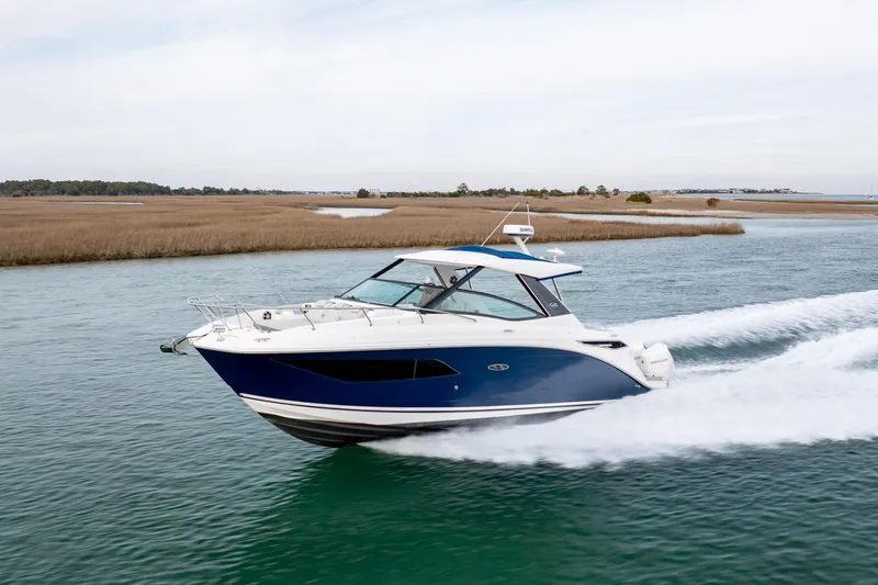 Slide: The Image of 2020 Sea Ray Sundancer 320 Outboard cruising on a serene waterway. - 18