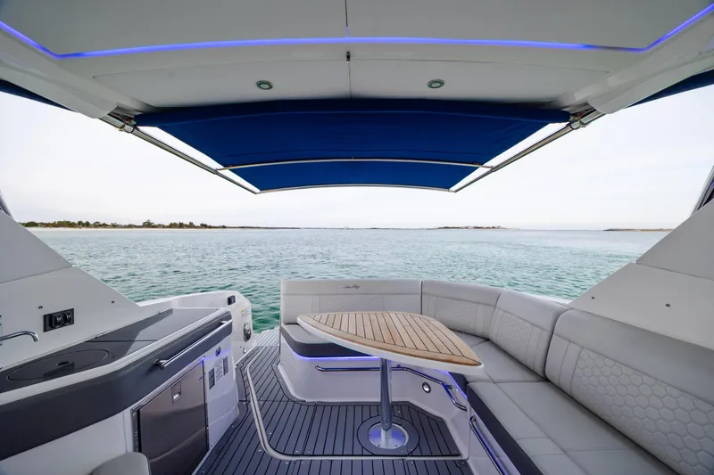 Slide: The Image of 2020 Sea Ray Sundancer 320 Outboard interior with seating, table, and ocean view. - 21
