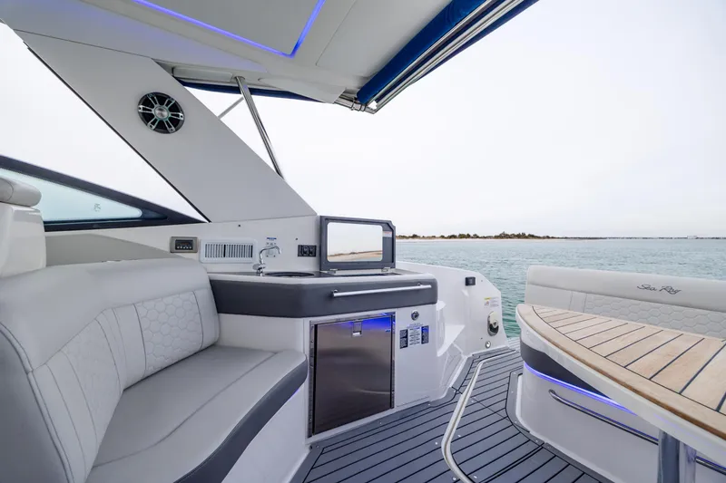 Slide: The Image of 2020 Sea Ray Sundancer 320 Outboard interior with seating, kitchenette, and ocean view. - 24