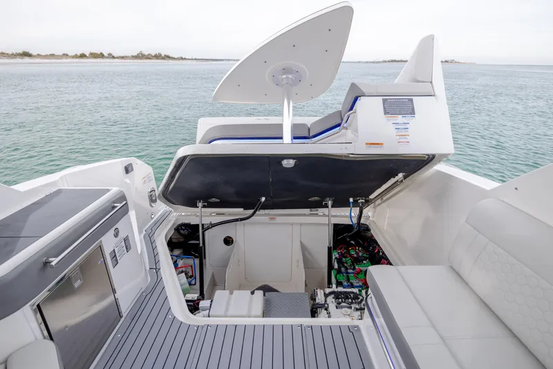 Slide: The Image of 2020 Sea Ray Sundancer 320 Outboard boat interior with open engine compartment, docked by the water. - 27