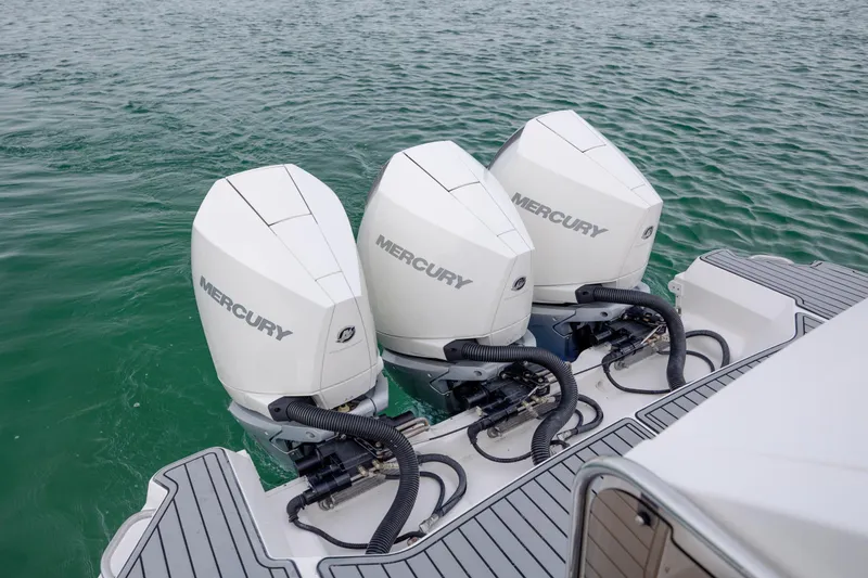 Slide: The Image of Triple Mercury outboard engines on a 2020 Sea Ray Sundancer 320, cruising in clear waters. - 36