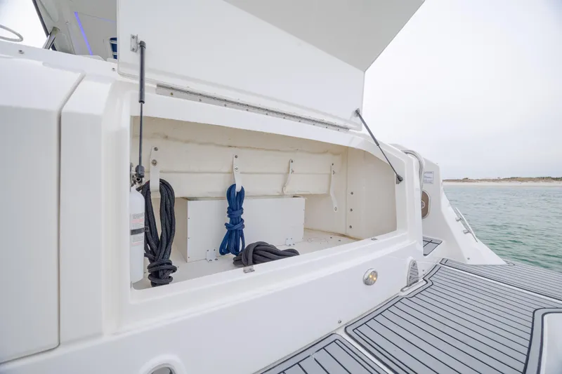 Slide: The Image of 2020 Sea Ray Sundancer 320 Outboard storage compartment with ropes and fire extinguisher. - 39