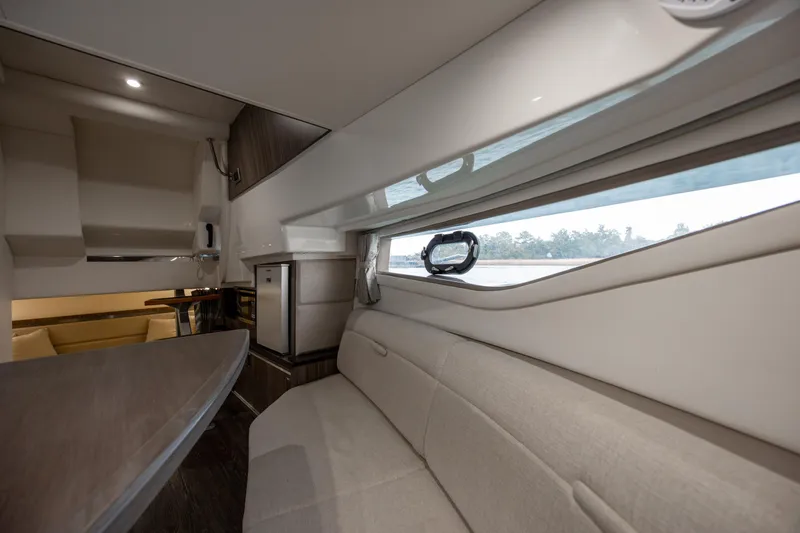 Slide: The Image of Interior of 2020 Sea Ray Sundancer 320 Outboard, featuring a cozy seating area and window view. - 49