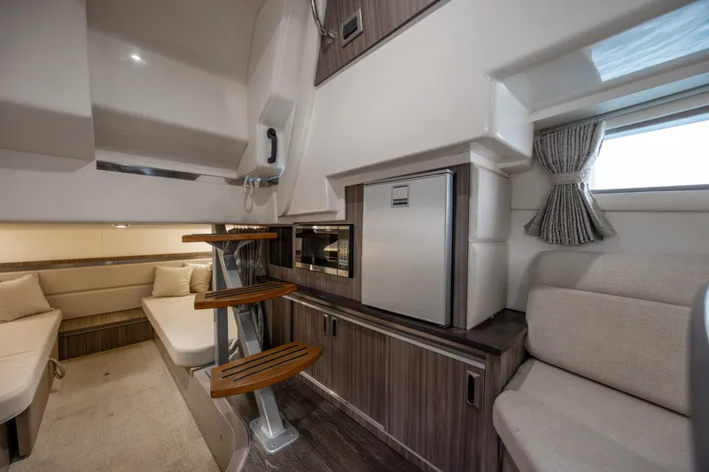 Slide: The Image of 2020 Sea Ray Sundancer 320 Outboard interior with modern seating and compact kitchenette. - 51